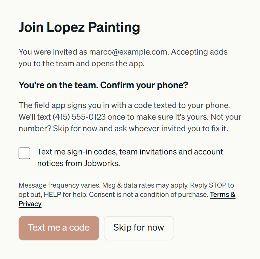 The Jobworks invitation page after joining a team. It reads: You're on the team. Confirm your phone? We'll text (415) 555-0123 once to make sure it's yours. Below is an unticked checkbox labelled: Text me sign-in codes, team invitations and account notices from Jobworks. Under it: Message frequency varies. Msg & data rates may apply. Reply STOP to opt out, HELP for help. Consent is not a condition of purchase. Terms & Privacy. The Text me a code button is dimmed and disabled; a Skip for now button sits beside it.